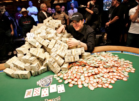 Игрок обнимает гору денег и фишек на столе